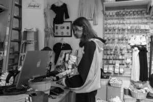 Small business owner working through an SEO checklist at the shop counter